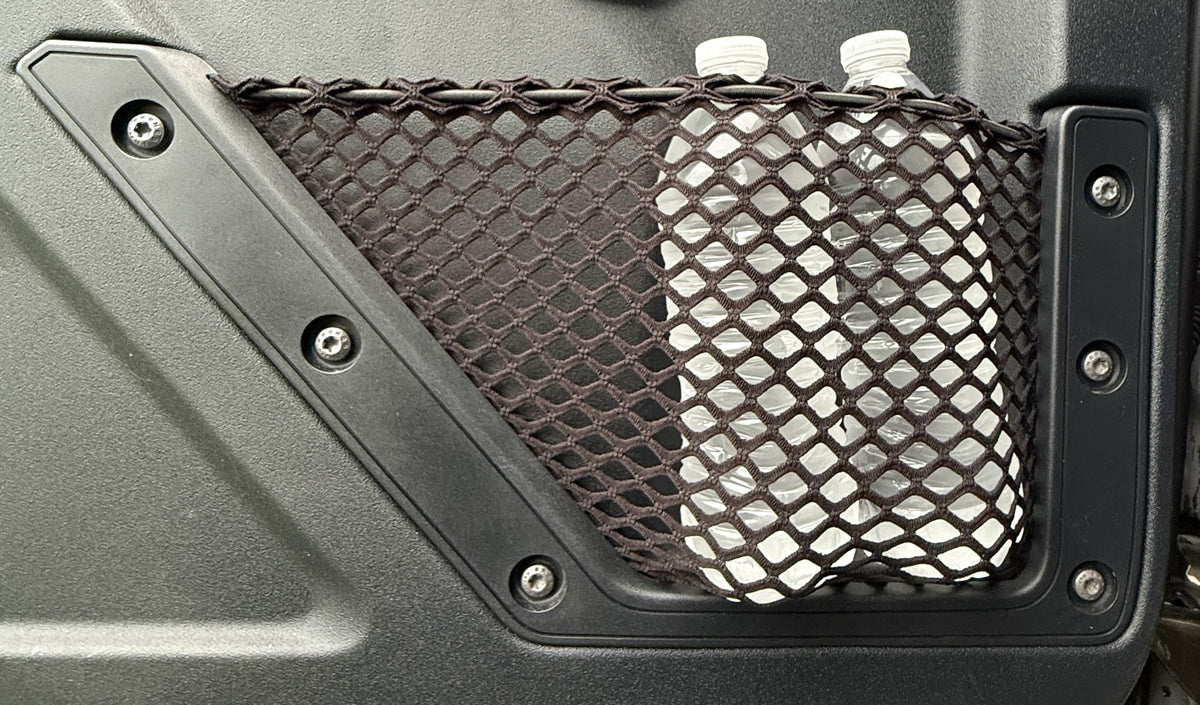 Detailed view of a mesh storage net installed into the original mounting spots on a Ford Bronco door panel, securely holding two water bottles.