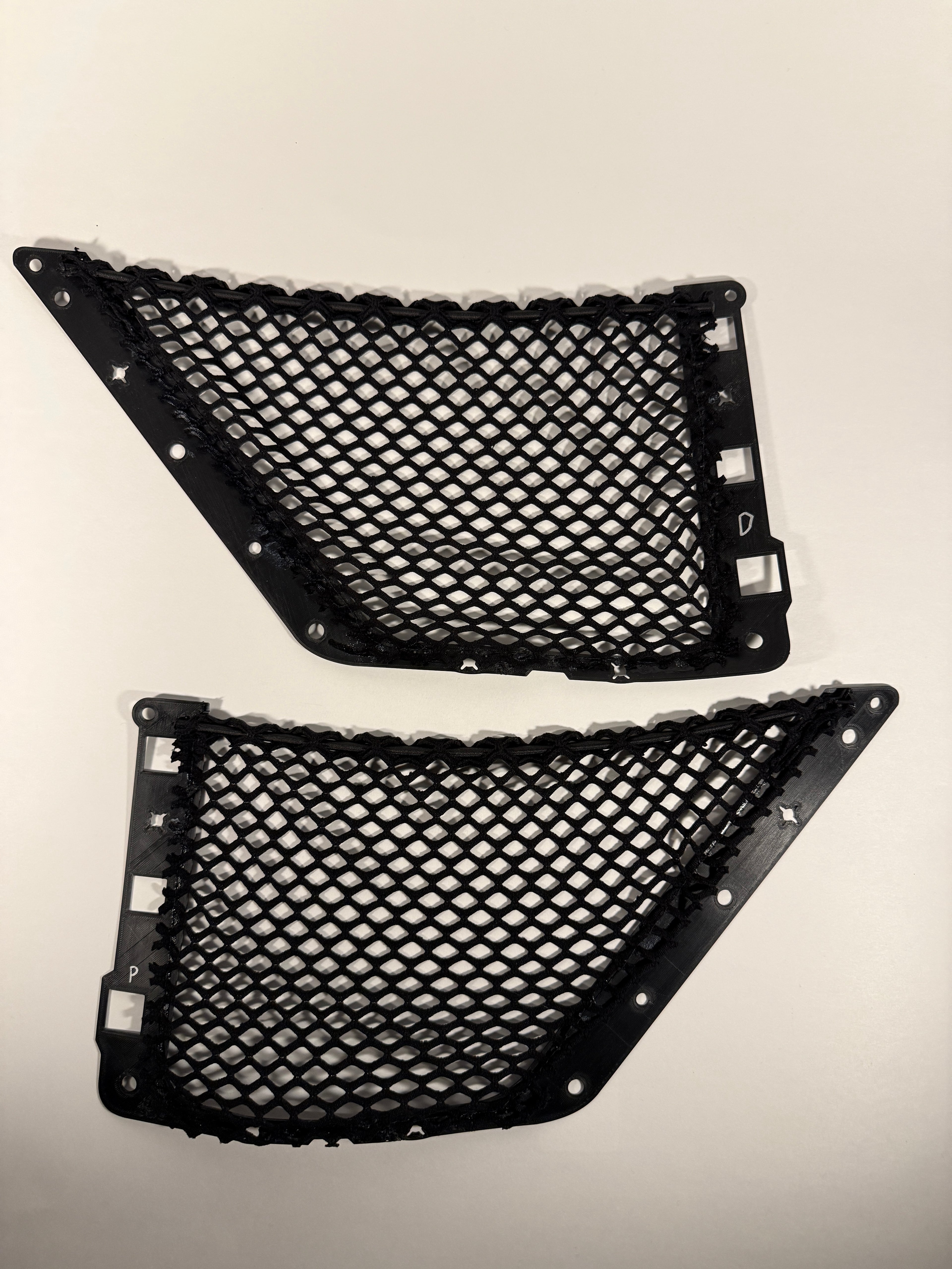 Two black mesh cargo net inserts with mounting clips, displayed against a plain, light background.
